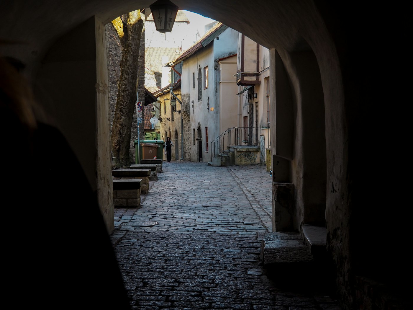 Kopfsteinpflastergasse in der Altstadt von Tallinn, durch einen Torbogen gesehen